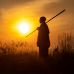 Die Silhoutte eines Massais im Sonnenuntergang