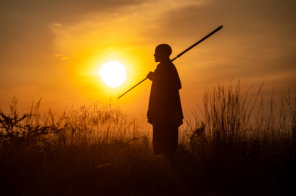 Die Silhoutte eines Massais im Sonnenuntergang