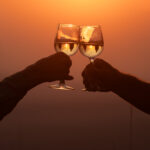 Priska und Hansruedi stossen mit einem Glas Wein an. Im Sonnenlicht reflektieren die Massai