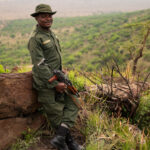 Ein Ranger steht auf einer Kuppe und hat sein Gewehr in der Hand
