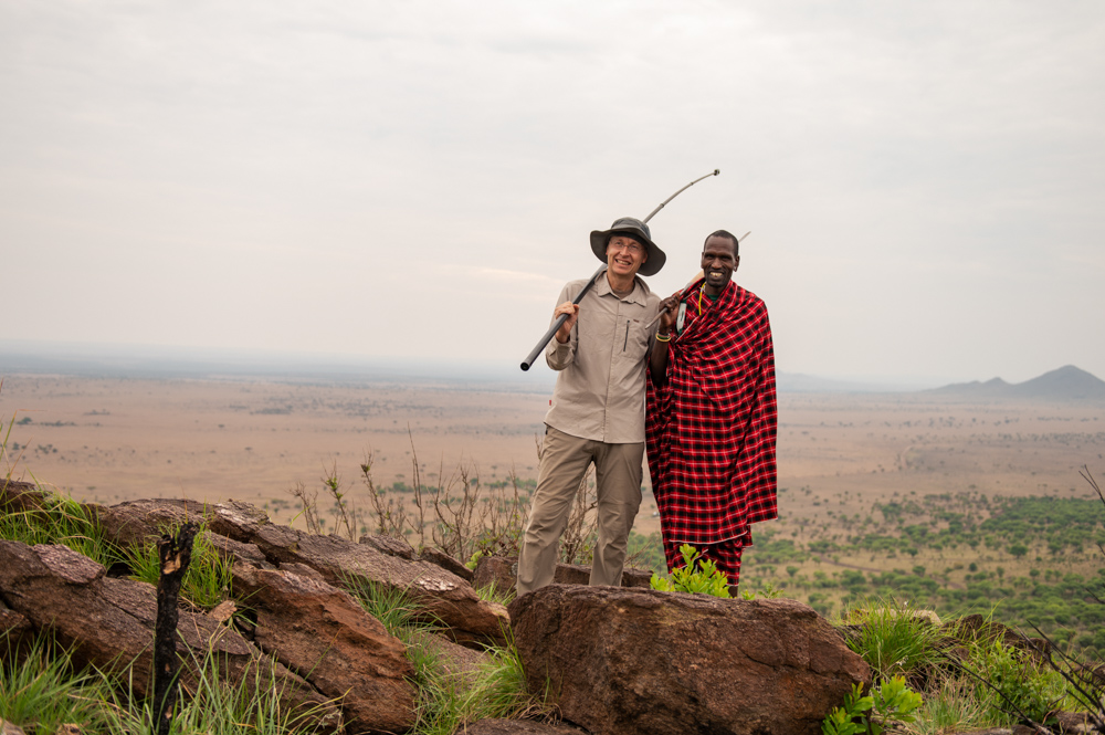 Ruedi und ein Massai stehen nebeneinander. Der Massai hält seinen Speer und Ruedi seinen Filmstick